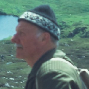 A close up of Tom Weir wearing his iconic cap, standing on a mountain.